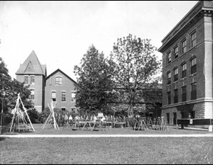 old black and white of the MSU engineering publications office with survey equipment in front of the building