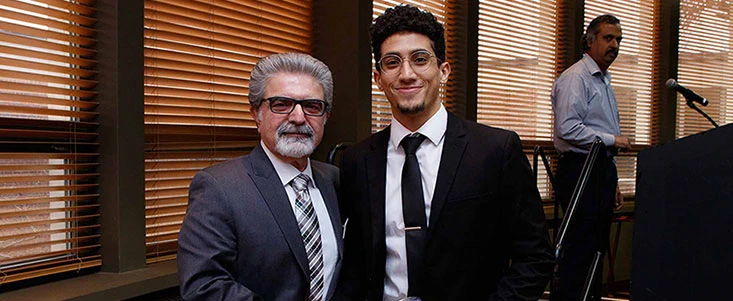 Smiling Chairperson Abdol-Hossein Esfahanian standing next to a Computer Science and Engineering Alumni at the Fall 2019 Grad Breakfast event. 