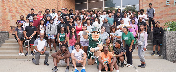 Group photo-op in front of the College of Engineering building with Sparty