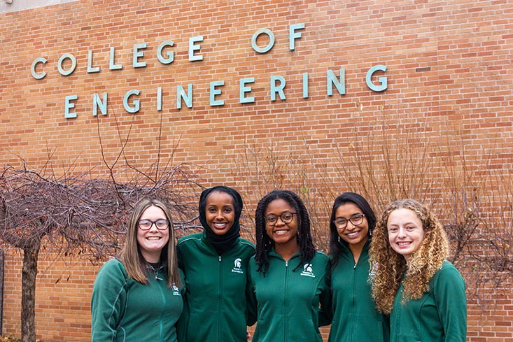 Women in Engineering Student ambassadors standing in a group right in front of the College of Engineering building