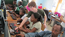 MSU students helping individuals with computers inside a building at Tanzania