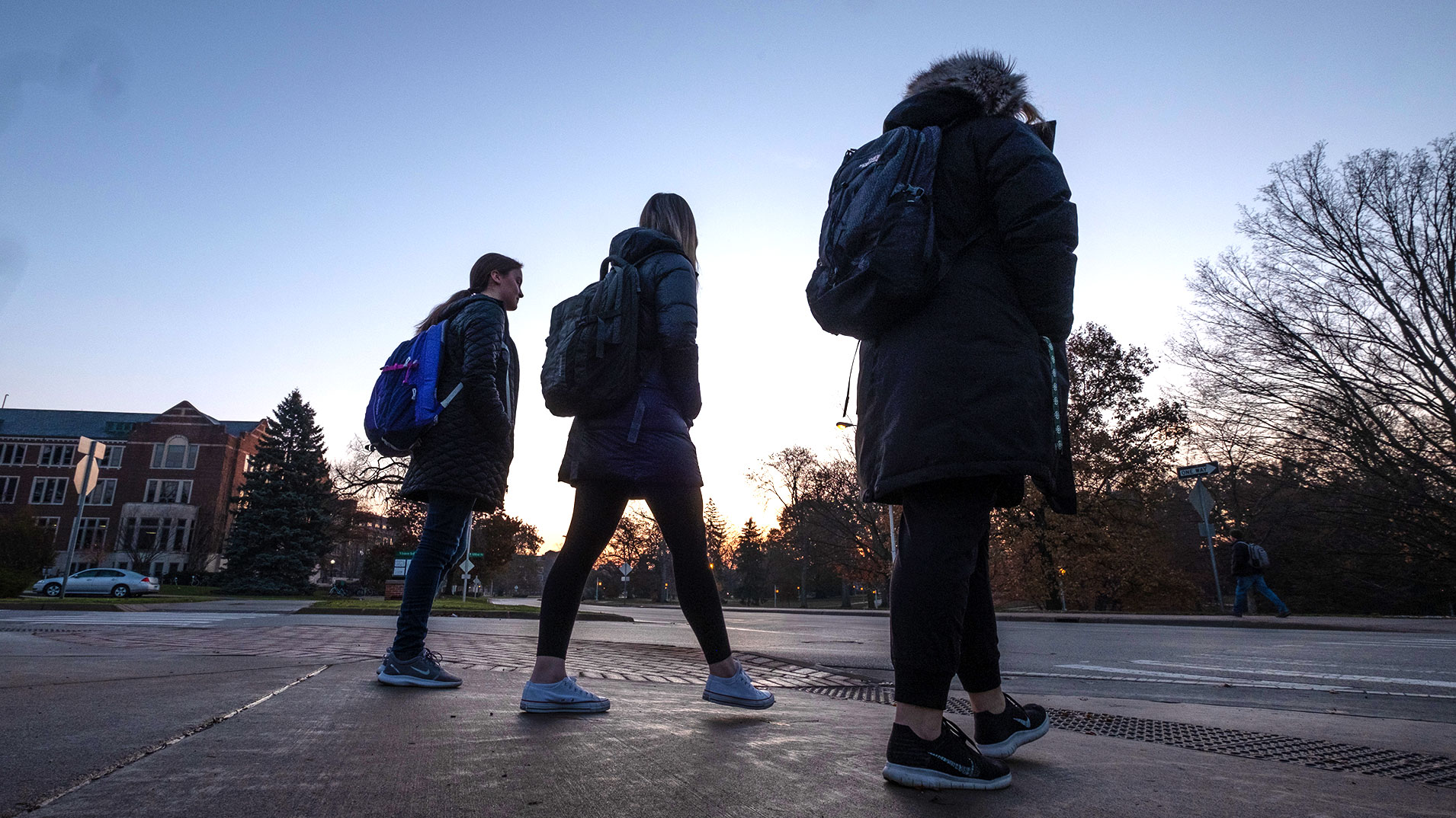 students walking while sun is setting