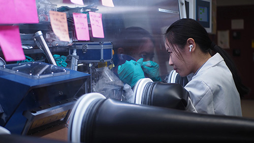 Doctoral student Jingjing Liu prepares a sample inside a glove box in the lab of Chengcheng Fang.