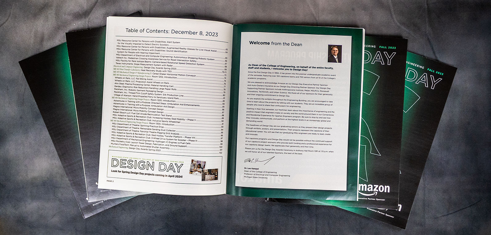 A spread of the Fall 2023 Design Day booklets, one book is open to show the Dean's message of Design Day