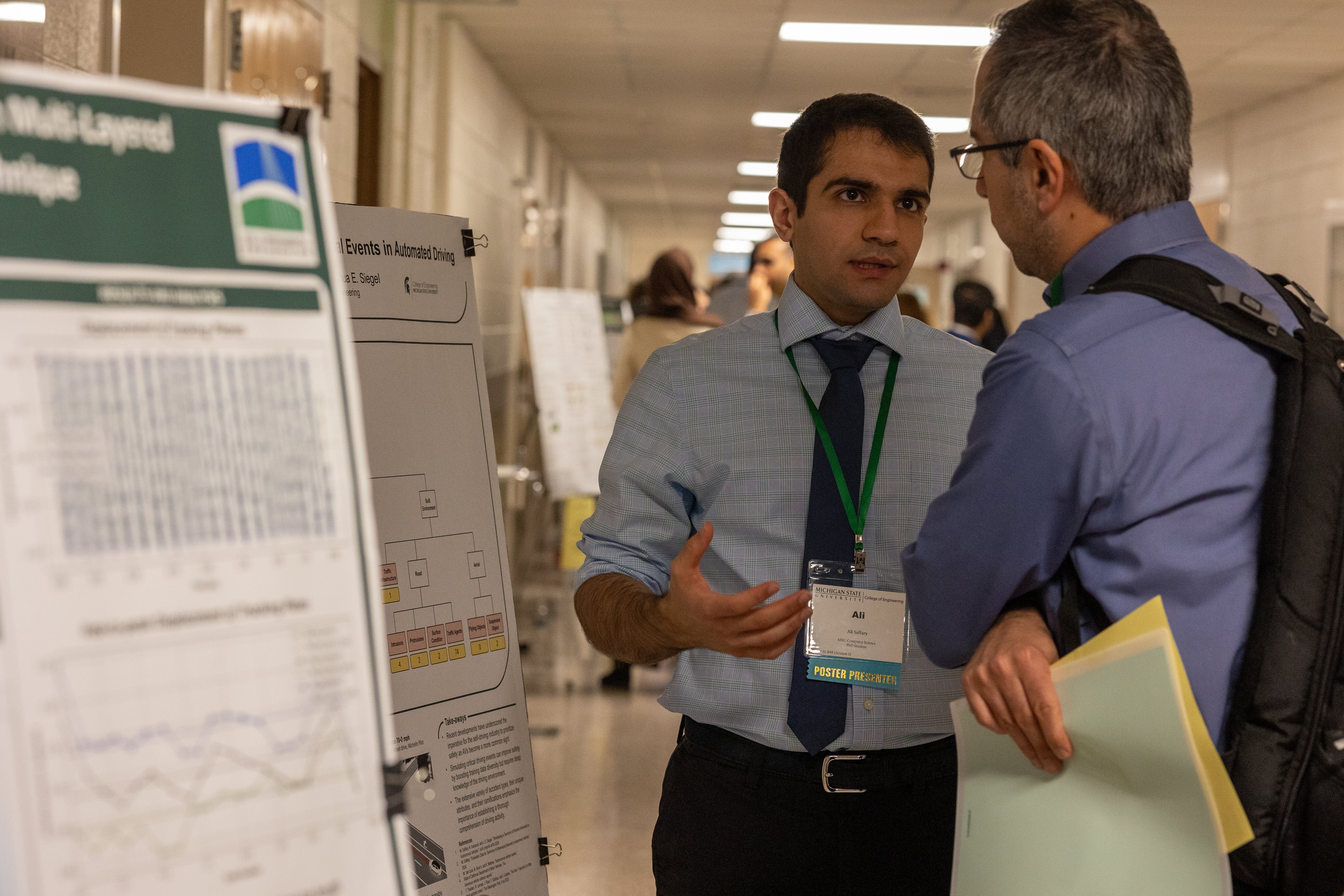 Student presenting their poster to a faculty member