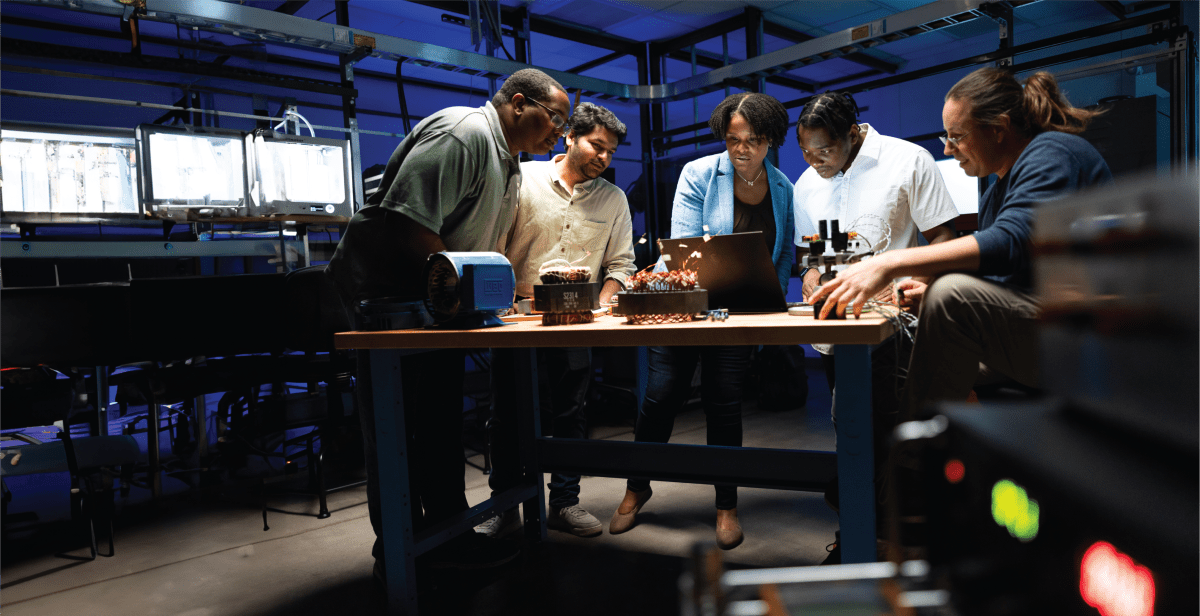 5 people in a lab standing around a table