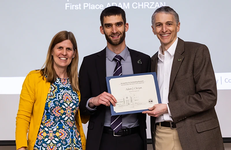 Adam Chrzan (center) took first-place honors in the Three Minute Thesis competition. He is with Tamara Reid Bush and Pat Walton.