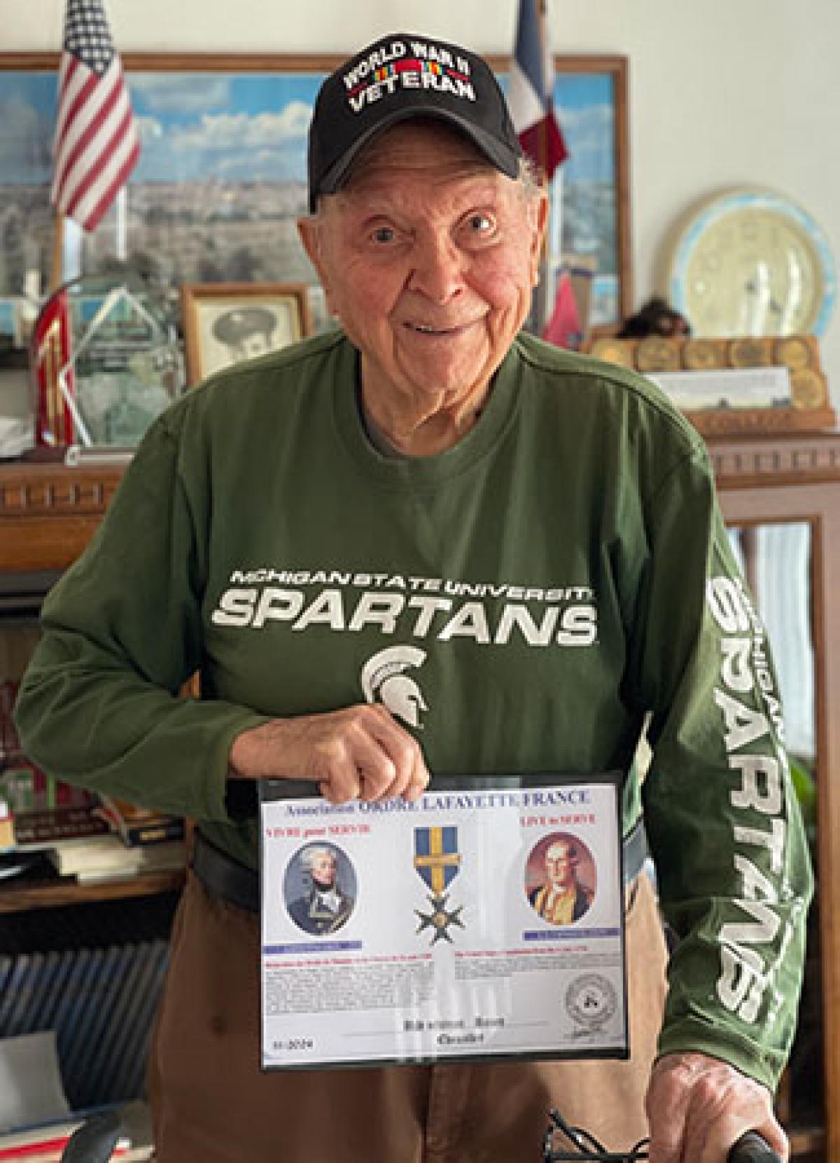 Ceo Baur holding information on his World War II military award from France.