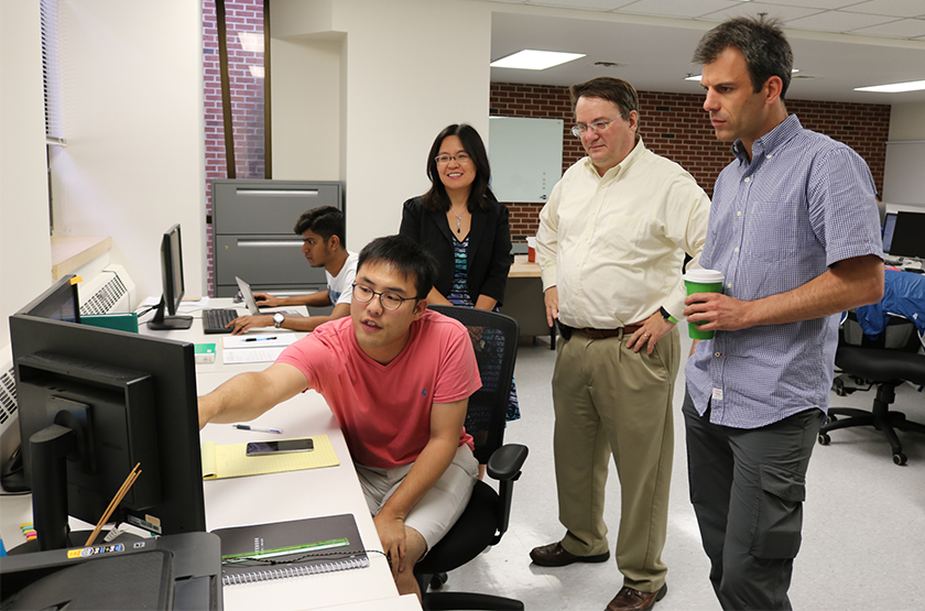 Materials science PhD student Kwang Jin Kim from South Korea explains his work to associate professor Yue Qi, Engineering Dean Leo Kempel and associate professor Philip Eisenlohr during the opening of MSU's new Materials Simulation Laboratory in the Engineering Building on Aug. 7.