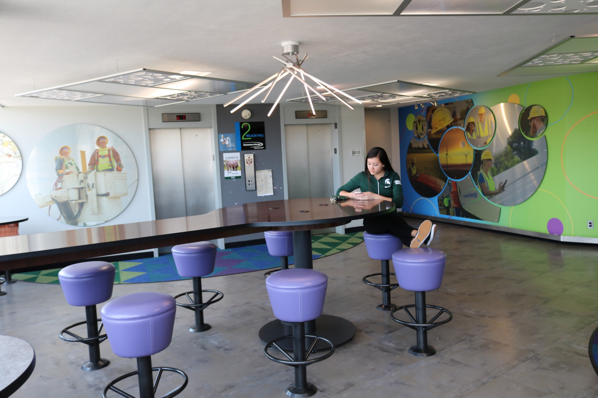 The second floor lobby of East Wilson Hall has been updated with contemporary furnishings, a big screen TV, and charging stations to help CoRe students like Megan Phanrisvong socialize, study, and collaborate.