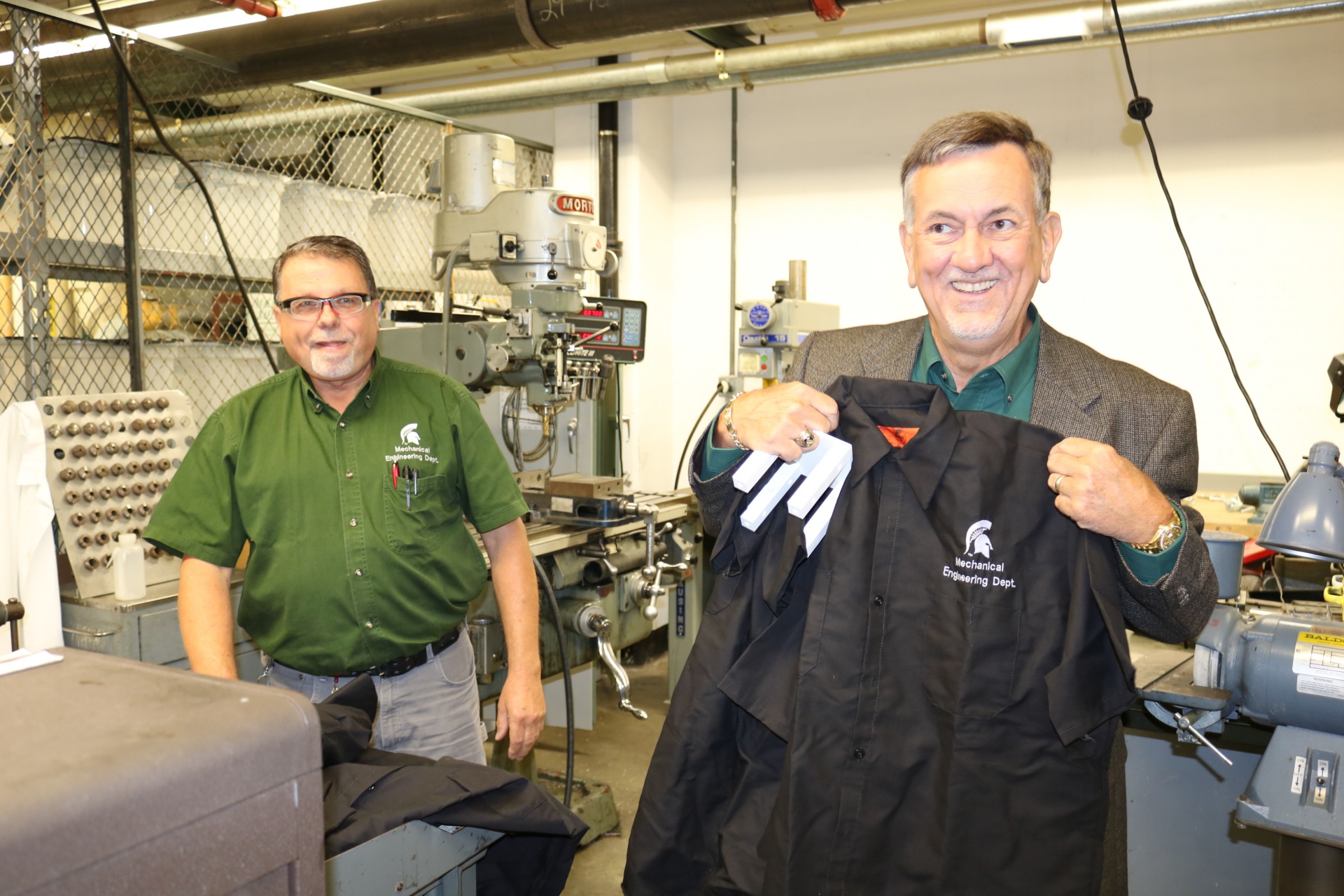 ME's Roy Bailiff presented a Spartan Mechanical Engineering shirt to a happy James A. Schmidt during a tour of the Engineering Building in September.