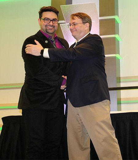 Nelson Sepulveda, who won the Emerging Accomplishments Award and a Teaching Excellence Award, is congratulated by Dean Leo Kempel.