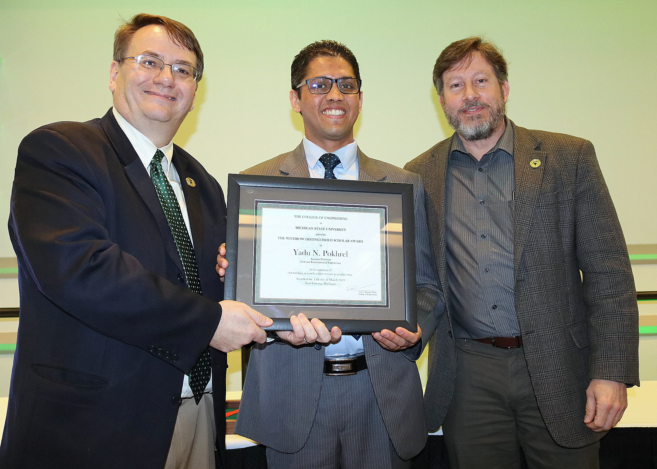 Dean Leo Kempel and Associate Dean John Verboncoeur presented the Distinguished Scholar - Junior Award to Yadu Pokhrel (center).