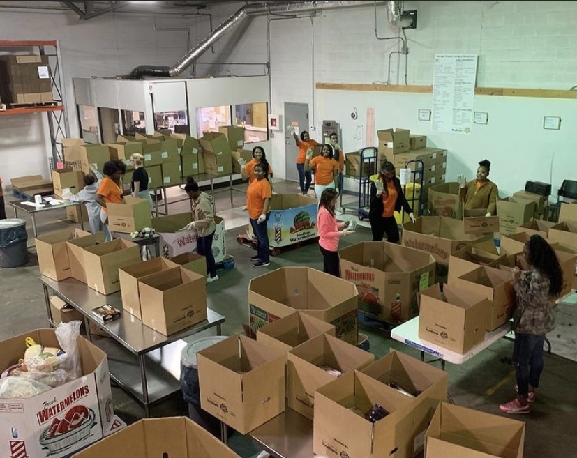 Yassah Bah-Deh ( left, tan jacket) volunteered at the Lansing Food Bank with Big Sister Little Sister mentoring program.