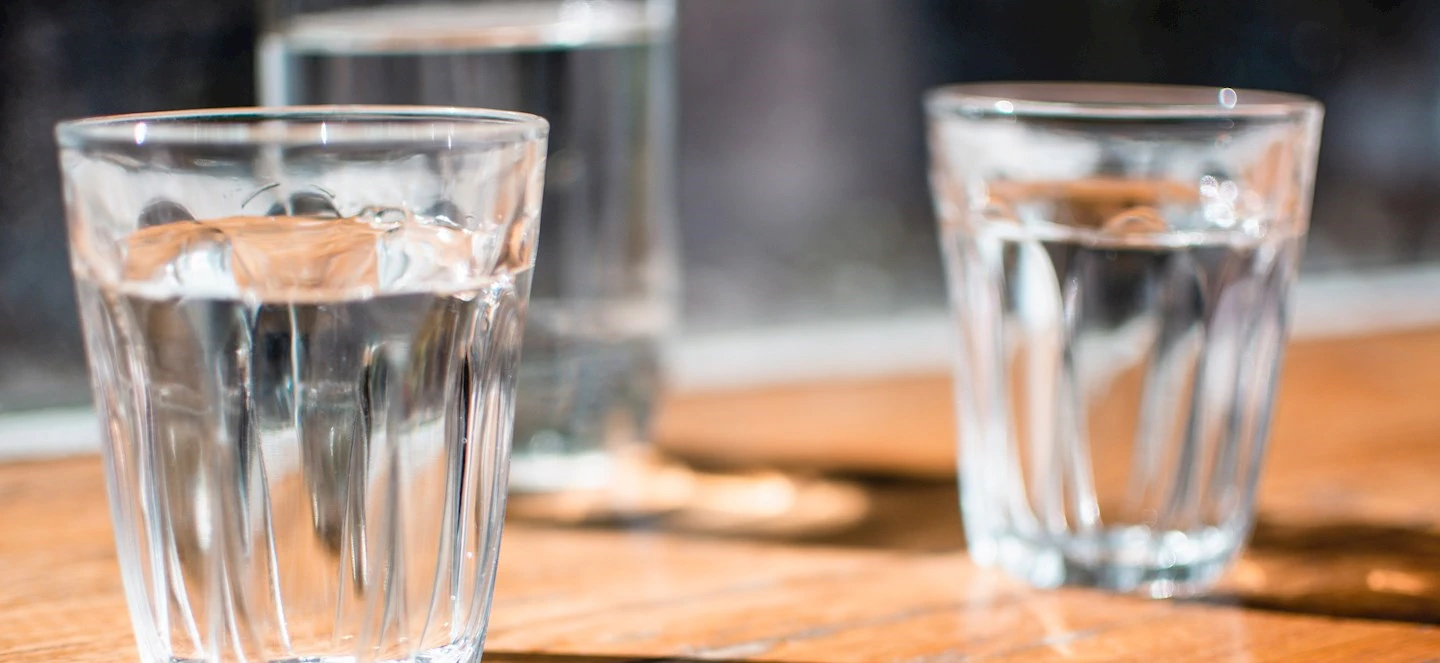 Glasses of water on a table with light shining through