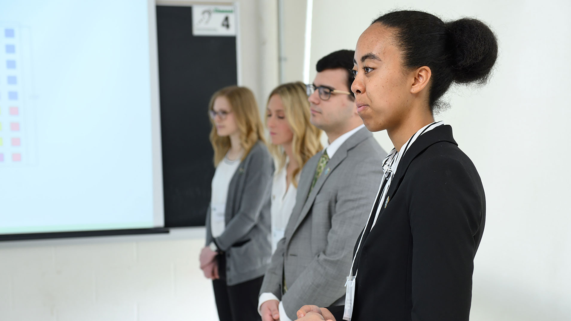 Group of students standing together wearing business attire