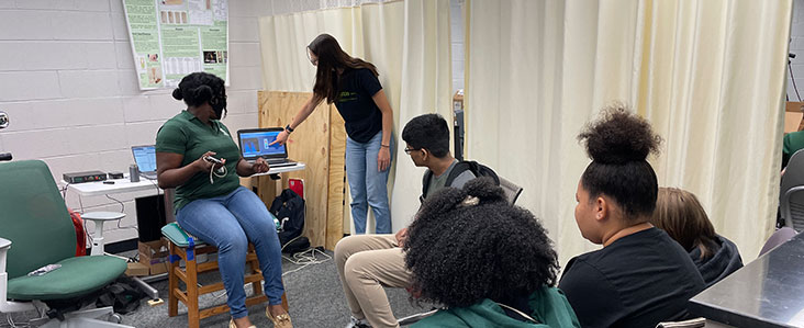 A group of students gathered in front of a computer