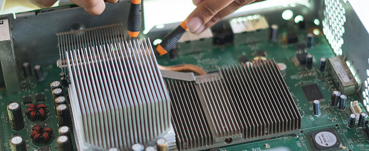 Close-up of an individual attaching a wire to a motherboard