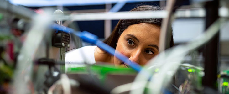 Individual looking at a 3D printer