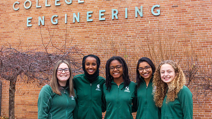 Women in Engineering Student ambassadors standing in a group right in front of the College of Engineering building