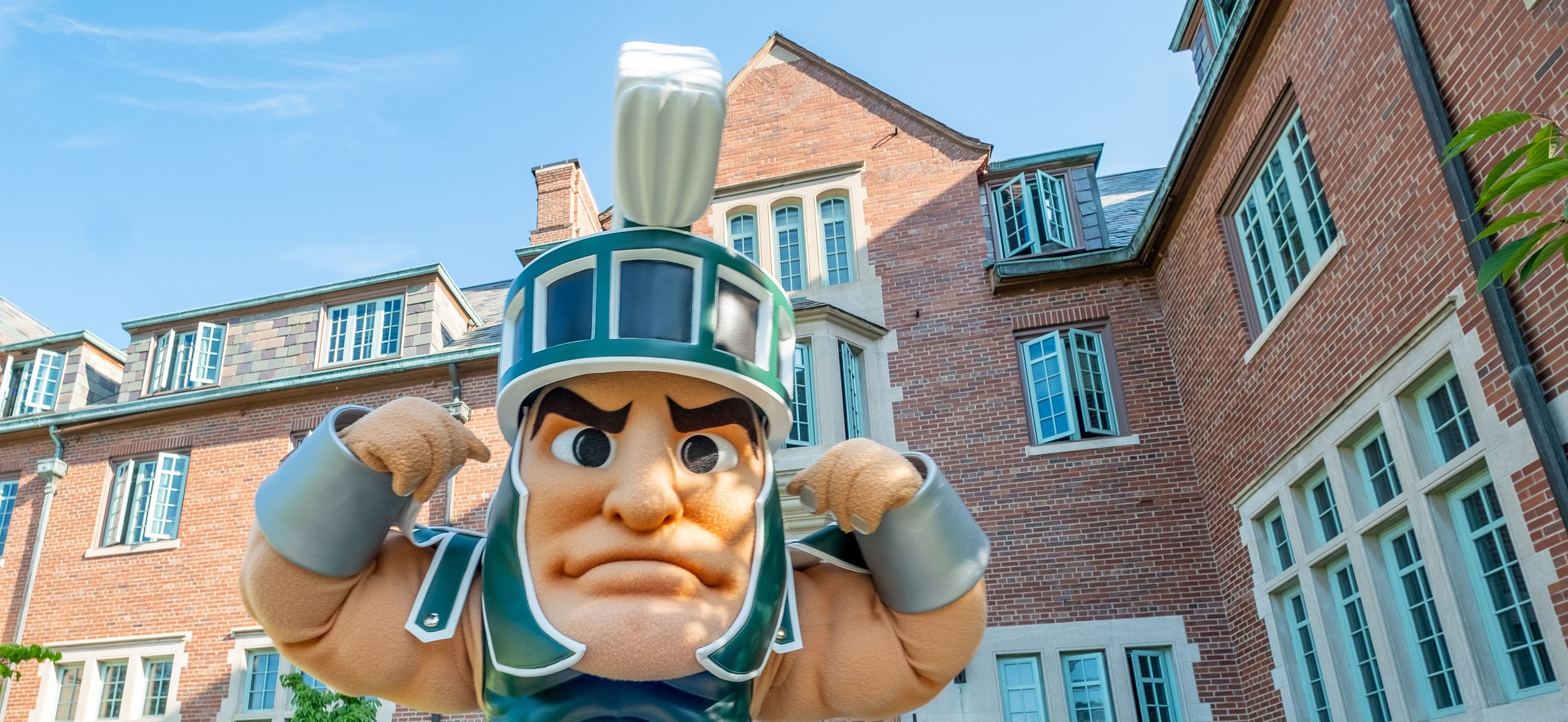 Sparty flexing his arm in a playful pose