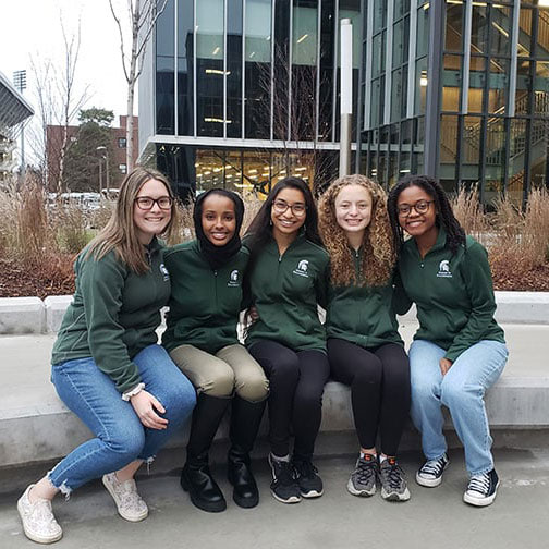 Students apart of Women in Engineering outside of the STEM Building
