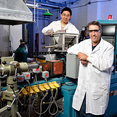Professor and graduate student next to a machine