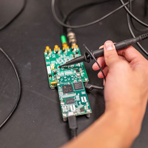 A student interacting with a circuit board