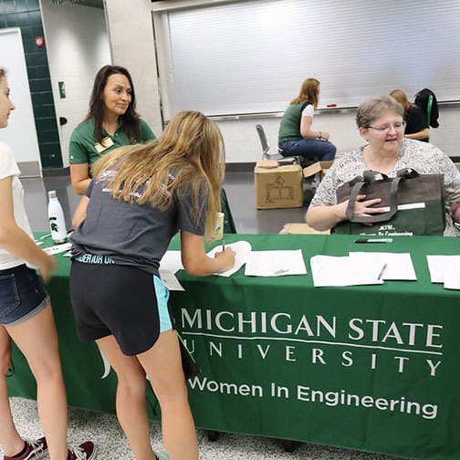 Two students signing up to join Women in Engineering during Colloquium