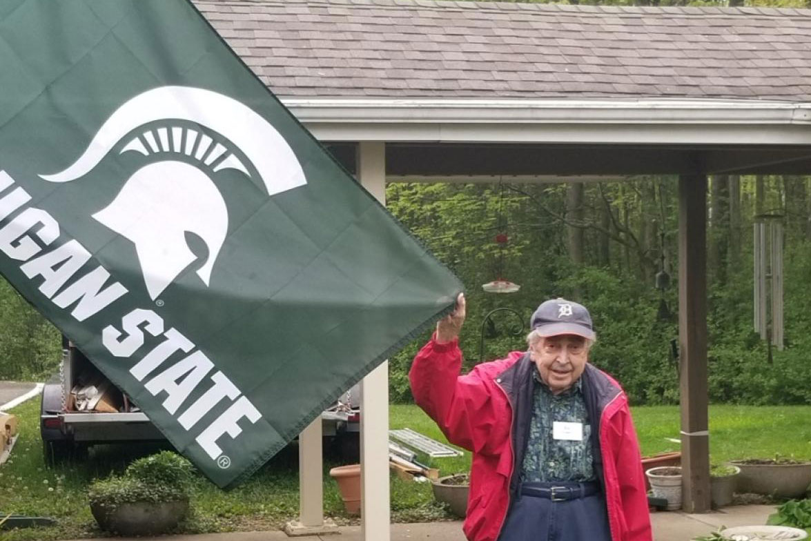 Joseph Colucci posing with the MSU flag