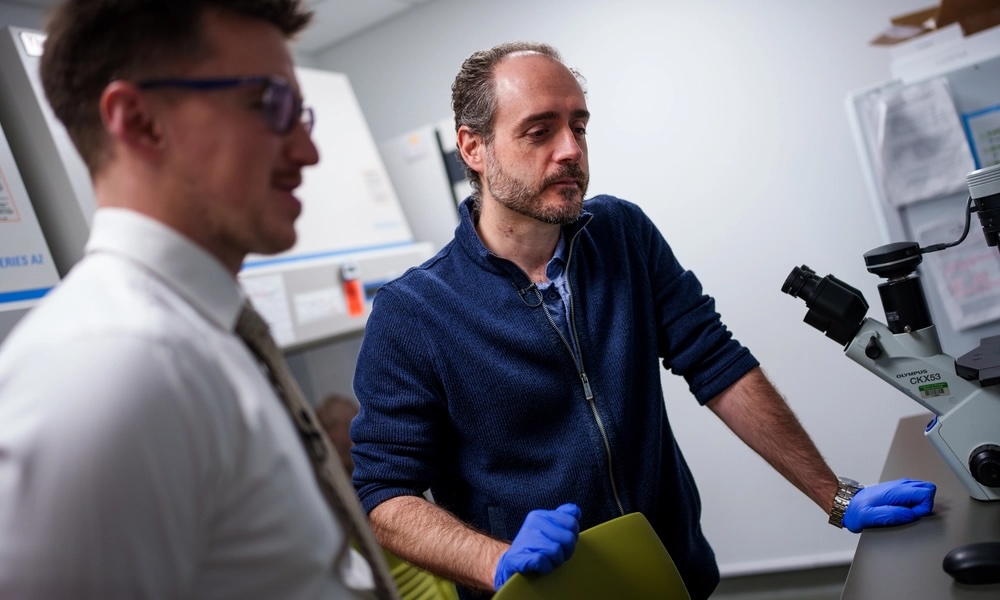 Two individuals looking at their research