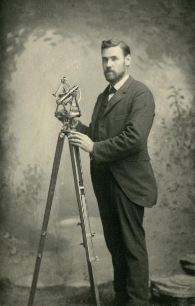 Black and White of Rolla C. Carpenter next to a old engineering equipment