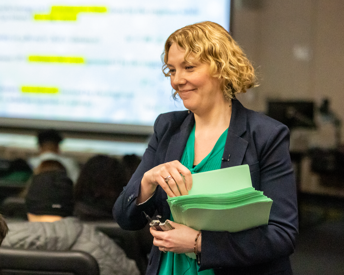 Professor Jenahvive Morgan handing out exams to students in a classroom