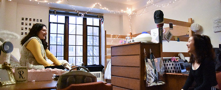 Two students having a conversation in their dorm room