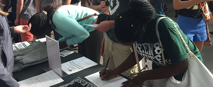 Student signing a form to join a student group