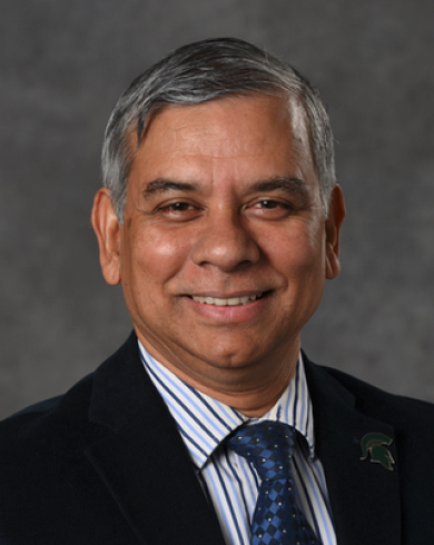 Kalyanmoy Deb smiling at the camera in a suit