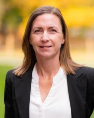 Angelika Braig smiling at the camera in a suit outside