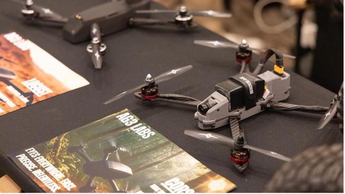 Aerial drones sit on a table waiting to take flight