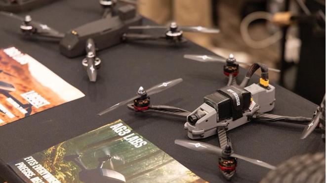 Aerial drones sit on a table waiting to take flight